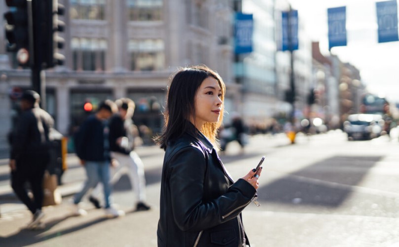 一个拿着手机的女人在街中央